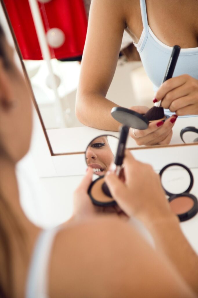 Beautiful young woman making make up near mirror home (1)