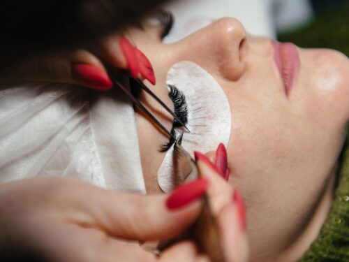 Eyelash extension procedure master tweezers fake long lashes beautiful female eyes