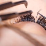 Eyelash extension procedure woman eye with long eyelashes lashes close up macro selective focus