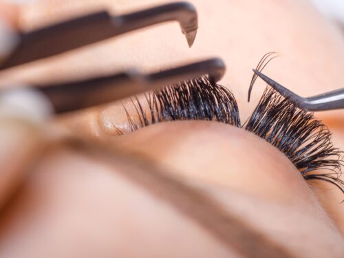 Eyelash extension procedure woman eye with long eyelashes lashes close up macro selective focus